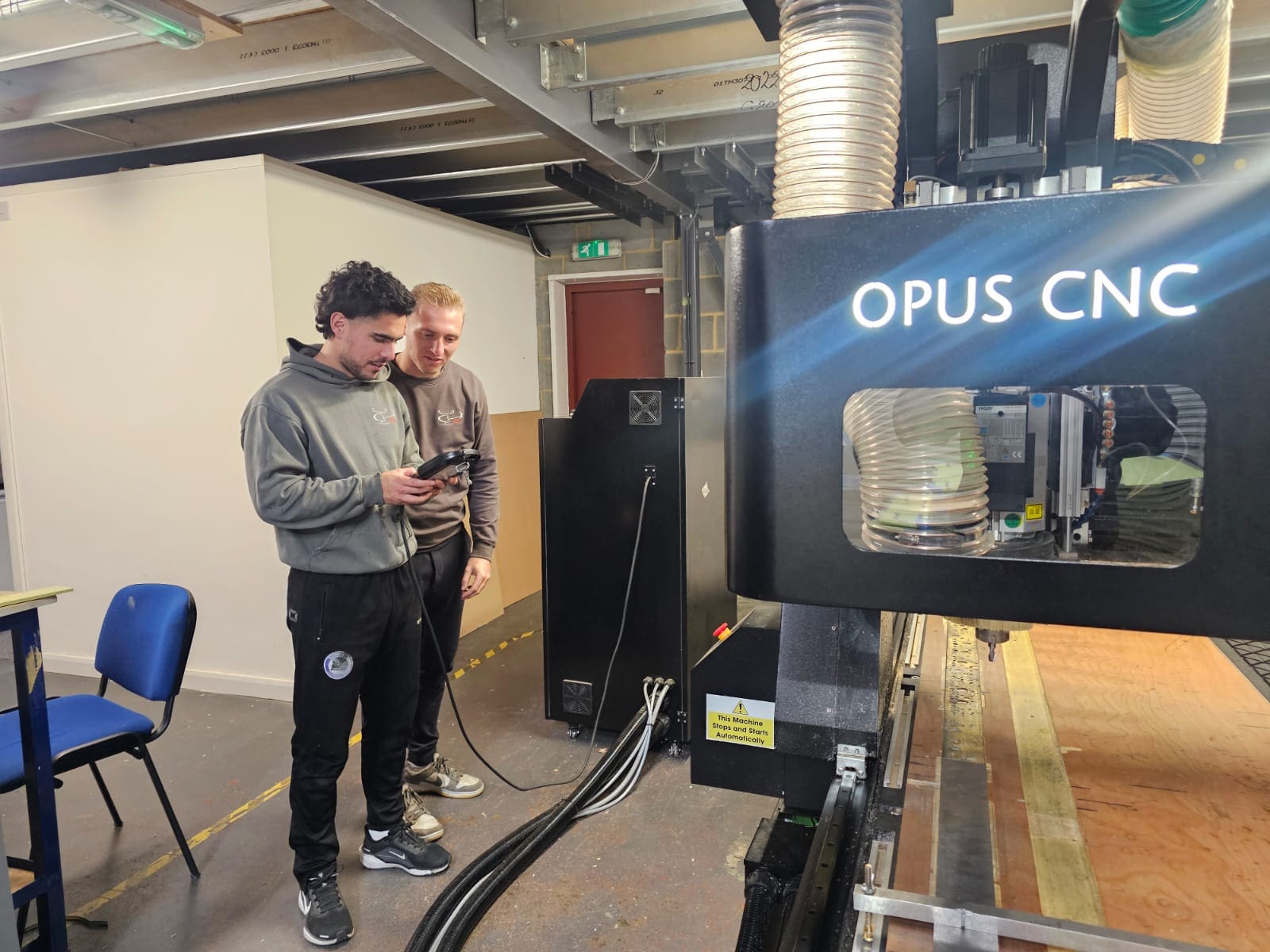 Operator supervising CNC router in modern manufacturing workshop.